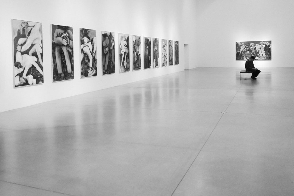 Visitor sitting on a bench in an art gallery