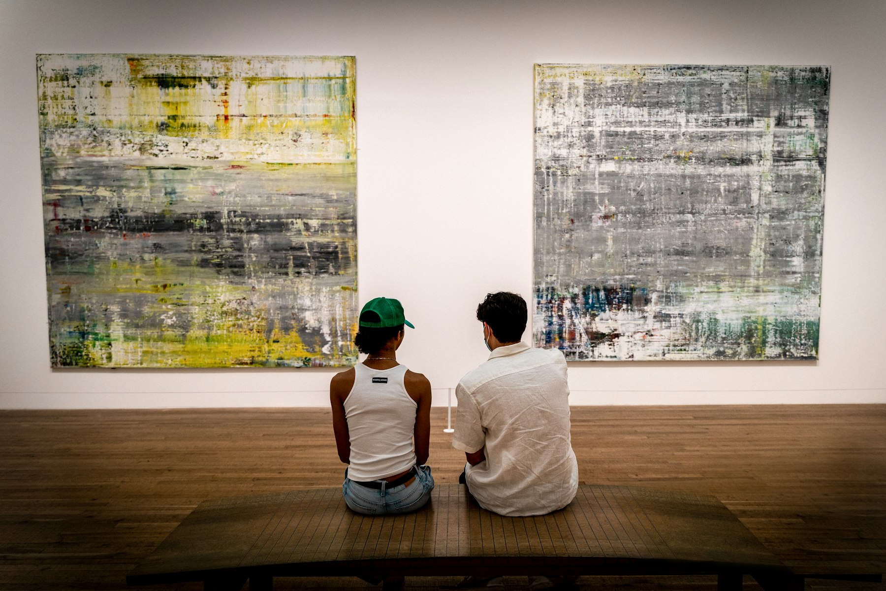 Two visitors discussing paintings in a gallery