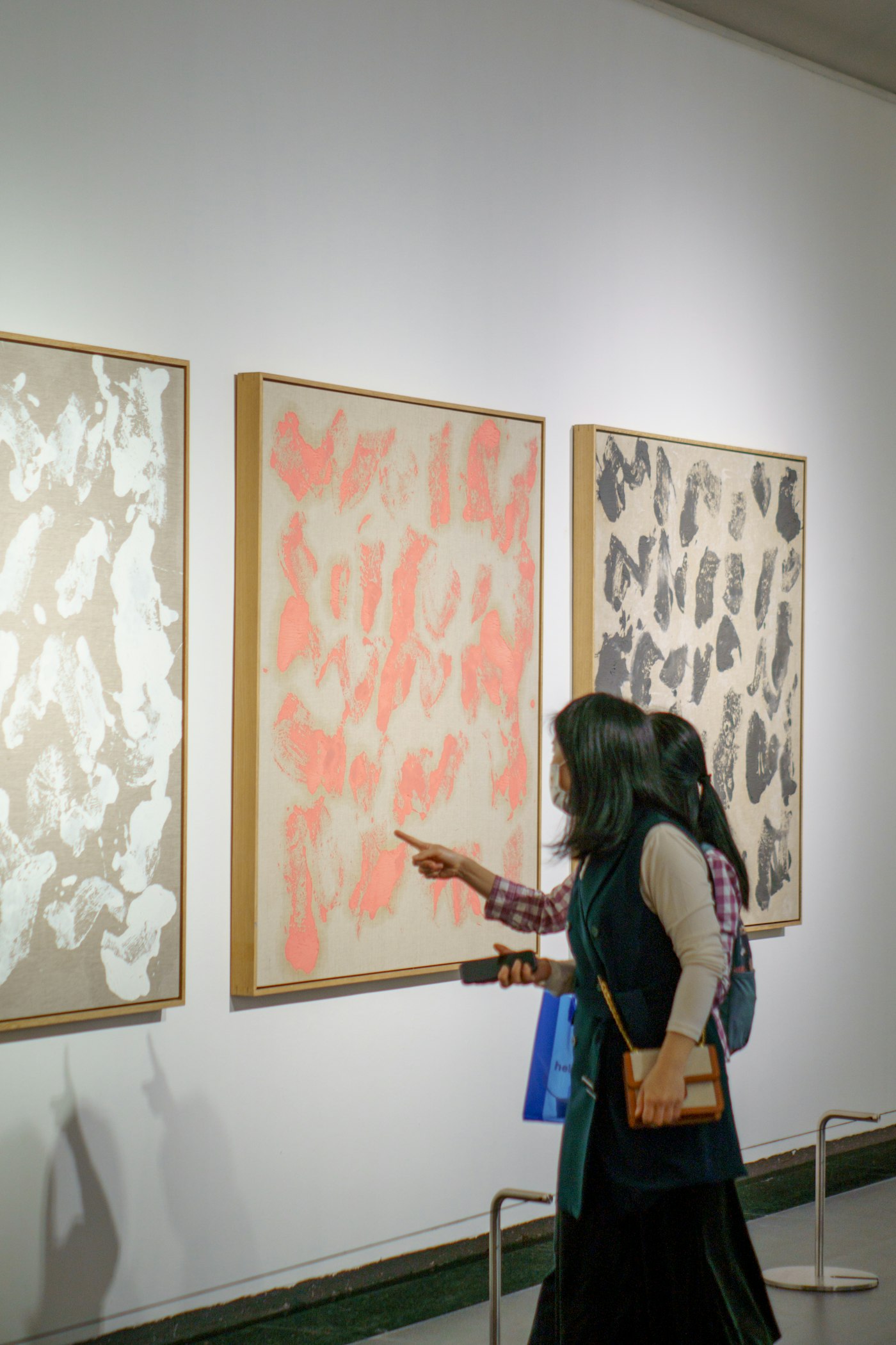 Woman looking at paintings on a wall